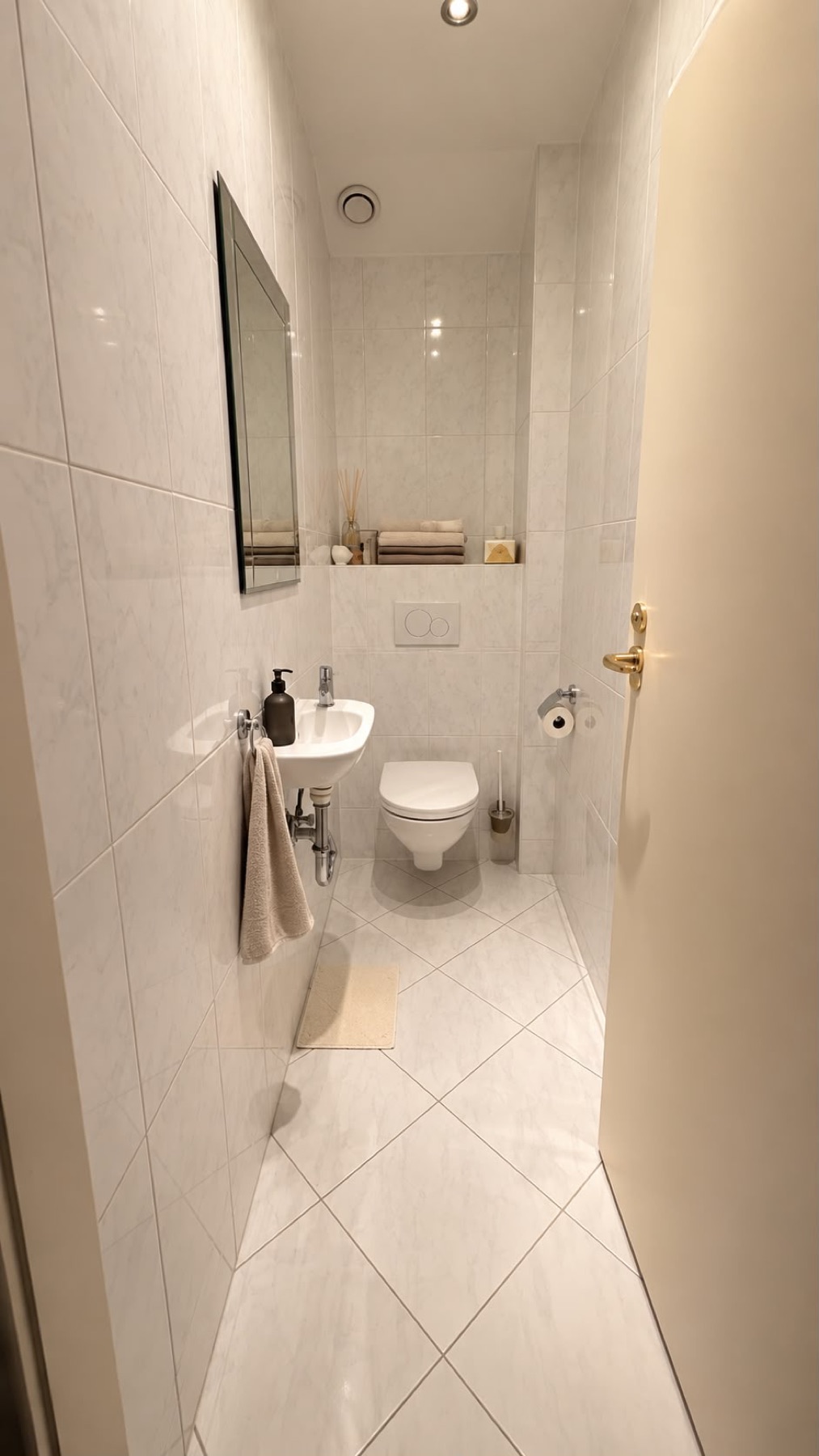 Separate tiled WC with wall-hung toilet and small washbasin